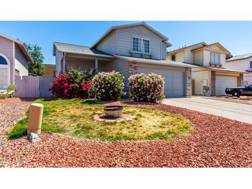 Charming two-story home featuring delightful curb appeal with bright pink and red bushes at 3829 W Camino Del Rio --, Glendale, AZ 85310