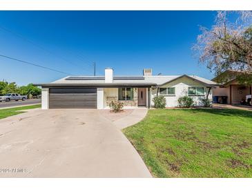 Charming single-story home with a brick facade, well-manicured lawn, and a two-car garage at 591 N Cheri Lynn Dr, Chandler, AZ 85225