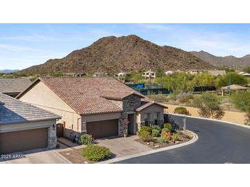 Charming desert home with a tile roof, beautiful stone accents, desert landscaping, and mountain views at 6948 E Quill St, Mesa, AZ 85207