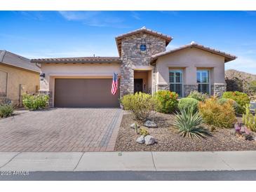 Beautiful desert home with stone accents, desert landscaping, brick driveway, and a two car garage at 6948 E Quill St, Mesa, AZ 85207