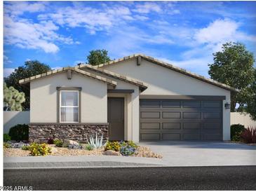 Charming single-story home featuring a two-car garage, stone accents, neutral colors, and a well-maintained desert-style yard at 7375 E Cozy Cottage Ln, San Tan Valley, AZ 85143