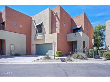 Modern two-story townhome featuring a two-car garage, landscaped front yard, and a stucco exterior finish at 7601 E Roosevelt St # 1012, Scottsdale, AZ 85257