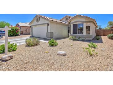 Charming home with a two-car garage, desert landscaping, and a cozy bay window at 10951 E Delta Ave, Mesa, AZ 85208