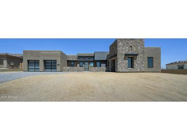 Contemporary home showcasing a blend of stucco and stone, complemented by a clean, modern driveway at 13290 E La Junta Rd, Scottsdale, AZ 85255