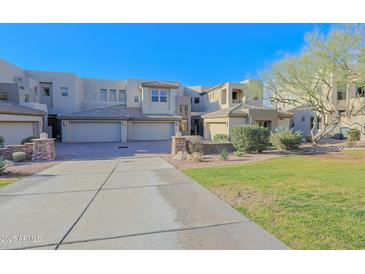Inviting exterior view of home featuring a multi-car garage, desert landscaping, and architectural details at 14850 E Grandview Dr # 138, Fountain Hills, AZ 85268