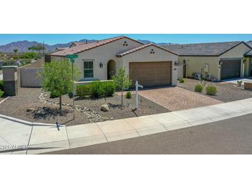 Charming single-story home boasts a paver driveway, a 2-car garage, and low maintenance desert landscaping at 15817 S 177Th Dr, Goodyear, AZ 85338