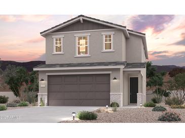 Inviting two-story home featuring a neutral color palette, a two car garage, and desert landscaping at 17373 W Jessie Ln, Surprise, AZ 85387