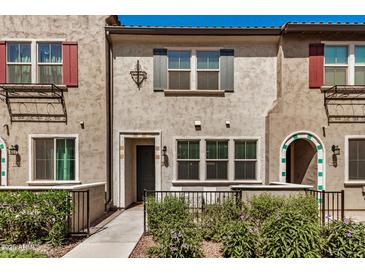 Charming townhome featuring a neutral stucco facade, colorful shutters, and lush landscaping at 2631 S Sulley Dr # 104, Gilbert, AZ 85295
