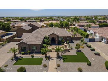 Stunning home featuring desert landscaping, palm trees and a stone facade at 10033 W Jj Ranch Rd, Peoria, AZ 85383
