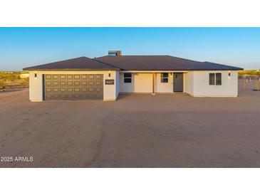 Charming single-story home featuring a gray garage door and a well-maintained desert landscape at 16627 N Slate Ln, Maricopa, AZ 85139