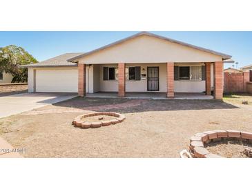 Charming single-story home featuring a covered porch with brick columns and a well-maintained front yard at 2227 N 57Th Dr, Phoenix, AZ 85035