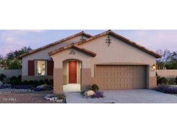 Charming single-story home showcasing a two-car garage, desert landscaping, and a covered entryway at 22631 W Irma Ln, Surprise, AZ 85387