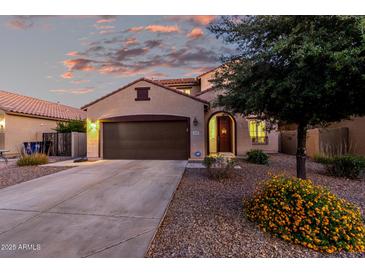 Charming single-Gathering home with a brown two car garage and colorful desert landscaping at 2993 E Meadowview Dr, Gilbert, AZ 85298