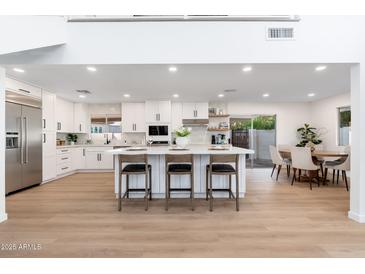 Well-equipped kitchen features white cabinetry, stainless appliances, and a large island with seating at 7223 N 14Th St, Phoenix, AZ 85020