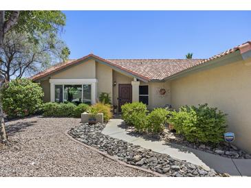 Charming front yard with desert landscaping, stone pathway, and tan exterior at 13593 N 91St Way, Scottsdale, AZ 85260