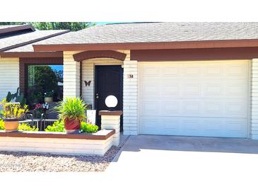 Charming home exterior with a front door, a garage, and decorative landscaping at 2064 S Farnsworth Dr # 38, Mesa, AZ 85209