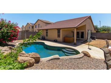 Sparkling private pool with rocky accents and mature bougainvillea at 25060 W Vista Norte St, Buckeye, AZ 85326