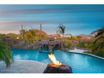 Inviting pool with rock waterfall, fire features, and desert views creating a luxurious outdoor oasis at 26285 N 89Th St, Scottsdale, AZ 85255