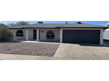 Charming single-story home featuring a well-manicured front yard and a two-car garage at 4151 E Clovis Ave, Mesa, AZ 85206