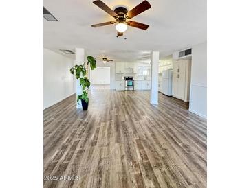 Spacious living room flows into an updated kitchen with new appliances and marble countertops and modern wood-look floors at 4916 W Earll Dr, Phoenix, AZ 85031