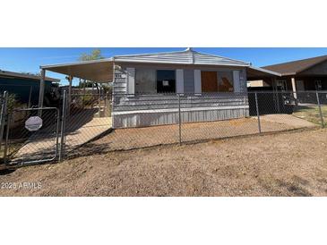 Exterior shot of a single story home featuring a fenced yard, covered porch, and mature landscaping at 614 W 12Th St, Casa Grande, AZ 85122