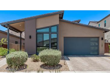 Contemporary single-Gathering home featuring desert landscaping, modern window design, and a convenient two-car garage at 939 E Paseo Way, Phoenix, AZ 85042