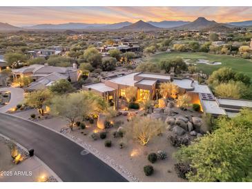 Expansive desert home with beautiful desert landscaping, mature trees, a nearby golf course, and stunning mountain views at 10664 E Monument Dr, Scottsdale, AZ 85262