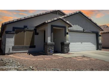 Charming single-story home with a two-car garage and low-maintenance desert landscaping at 14728 W Redfield Rd, Surprise, AZ 85379