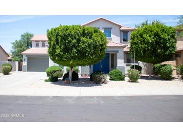 Charming two-story home with landscaped yard and a blue front door at 15148 W Sells Dr, Goodyear, AZ 85395