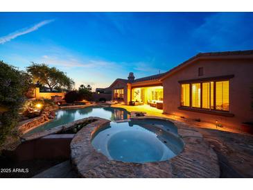 Inviting backyard pool and spa with beautiful landscaping and a seamless transition to indoor living at 17975 W Willow Dr, Goodyear, AZ 85338