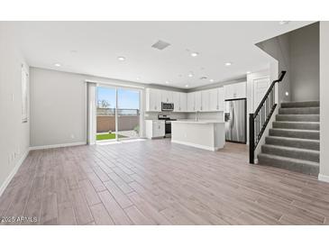 Bright living room with modern kitchen, stainless appliances, tile flooring, and sliding door to backyard at 21047 N 58Th Way, Phoenix, AZ 85054
