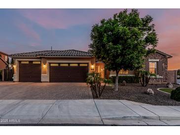 Charming home with a three-car garage, stone accents, and a well-manicured front yard at 2741 E Odessa St, Mesa, AZ 85213