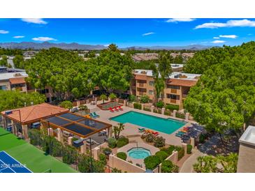 A gorgeous aerial view of the pool and spa with lounge seating and lush greenery at this lovely community at 3031 N Civic Center Plz # 355, Scottsdale, AZ 85251