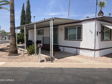 Charming single-story home featuring a covered porch, landscaped yard, and mature trees at 4065 E University Dr # 155, Mesa, AZ 85205