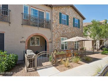 Charming townhouse featuring stone accents, a cozy patio, and a balcony for enjoying the outdoors at 4772 E Portola Valley Dr # 102, Gilbert, AZ 85297