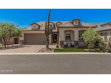 Charming single-story home with a neutral color palette, desert landscaping, and a brick-paved driveway at 8055 E Jaeger St, Mesa, AZ 85207