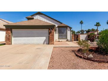 Charming home featuring a two-car garage, landscaped yard, and neutral exterior at 830 E Gila Ln, Chandler, AZ 85225