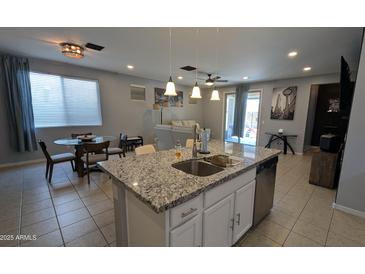 Modern kitchen boasts a large island with granite countertops, stainless steel appliances, and an open concept layout at 8419 S 40Th Dr, Laveen, AZ 85339