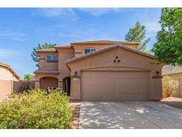 Charming two-story home with a two car garage and a well maintained landscaped front yard at 17851 W Calavar Rd, Surprise, AZ 85388