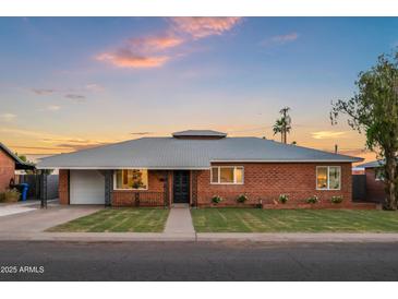 Charming brick home featuring a well-manicured lawn and stylish landscaping, showcasing curb appeal at 2225 E Monterosa St, Phoenix, AZ 85016