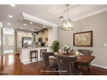 Staged dining area with wood table, elegant chandelier, and view into the beautifully appointed kitchen at 4401 N 24Th Pl, Phoenix, AZ 85016
