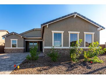 Charming single-Gathering home with gray stucco, stone accents, and neat landscaping, under a clear blue sky at 16455 W Avenida Del Sol --, Surprise, AZ 85387