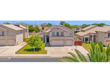 Charming two-story home features a well-manicured lawn, mature trees, and a spacious two-car garage at 1755 N 74 Th Pl, Mesa, AZ 85207