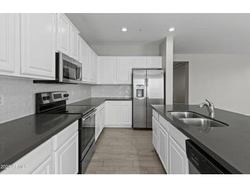 Modern kitchen with stainless steel appliances, white cabinetry, and tile flooring at 29302 N 126Th Ln, Peoria, AZ 85383