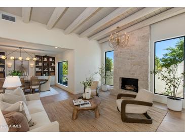 Bright living room boasts a stone fireplace, wood beam ceiling, and ample natural light at 3186 E Stella Ln, Phoenix, AZ 85016