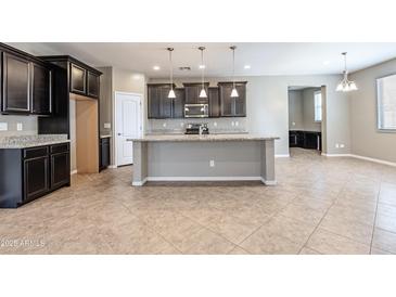 A kitchen showcasing an island, granite countertops, and dark wood cabinets at 4277 N 180Th Ln, Goodyear, AZ 85395