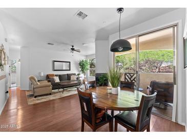 Bright dining area features a wood table and access to outdoor balcony, seamlessly blending indoor and outdoor living at 9550 E Thunderbird Rd # 214, Scottsdale, AZ 85260