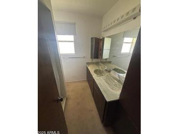 Neutral bathroom featuring a marble countertop, a mirror, and natural light at 121 E Ivanhoe St, Gilbert, AZ 85295