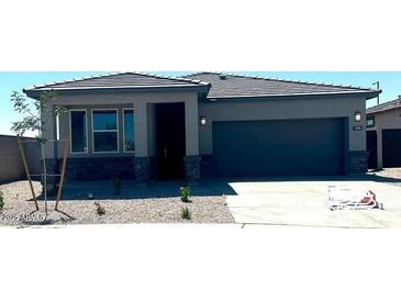 Charming single-story home featuring a two-car garage, low maintenance landscaping, and a welcoming entrance at 25096 N 154Th Ln, Surprise, AZ 85387