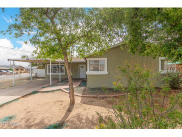 Charming single story home features a carport, desert landscaping, and a covered front porch at 3802 N 50Th Ave, Phoenix, AZ 85031